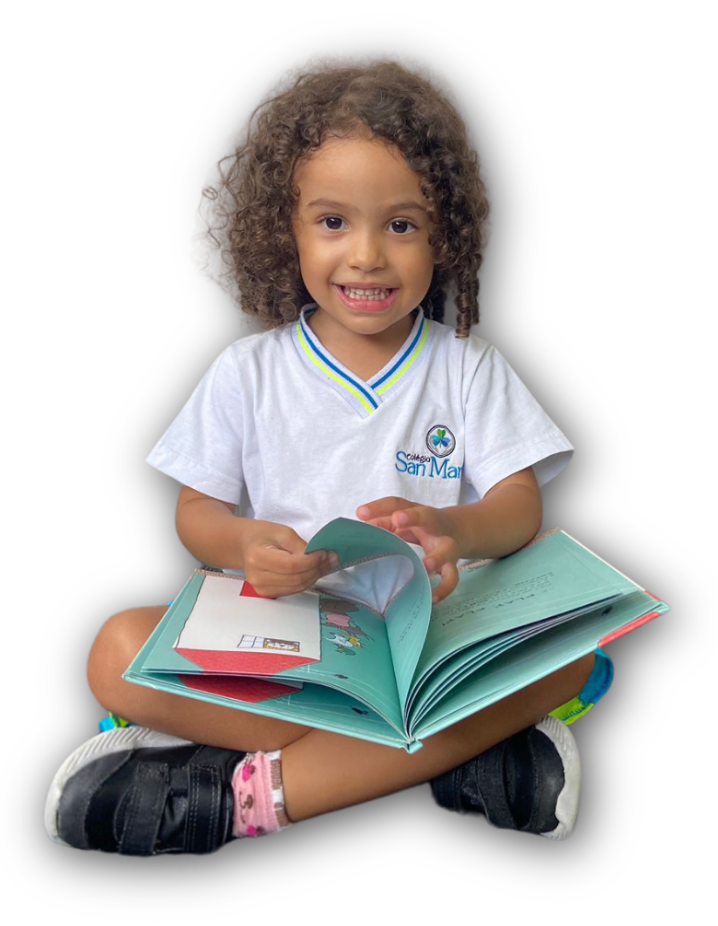 Uma jovem garota sentada no chão segurando um livro.